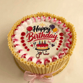 Layered birthday cake decorated with chocolate curls and a printed photo
