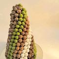 Close view of mini truffle chocolate balls coated in feuillantine, pistachio and coconut